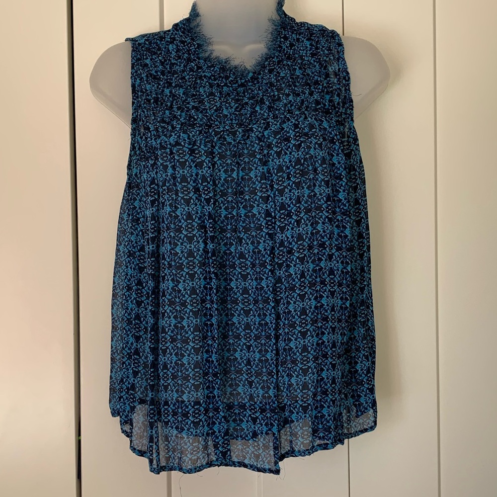 Gauzy A sleeveless blouse with smocked bodice and raw edge collar.